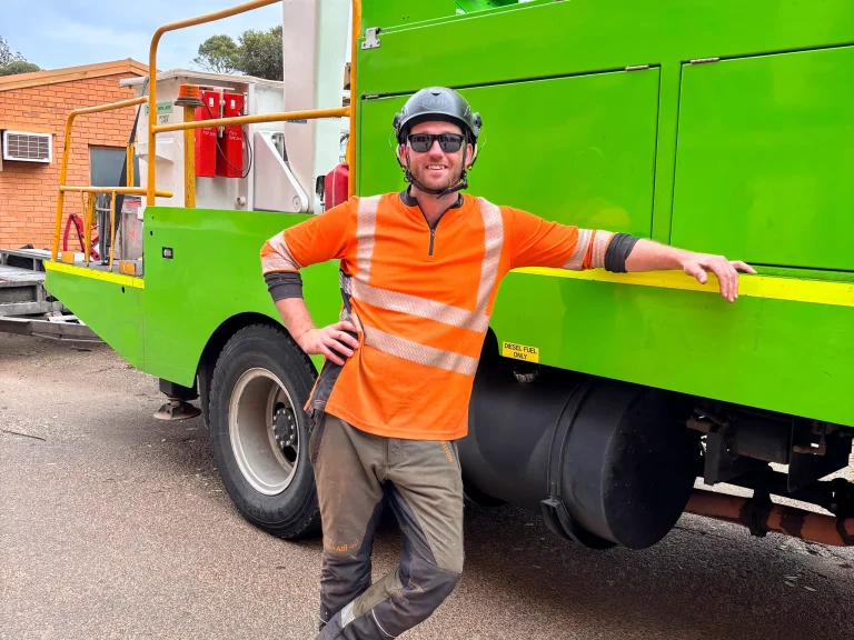 Arborist team leader in safety gear by utility vehicle