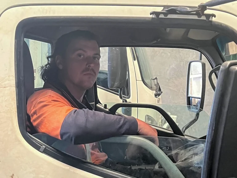 Arborist in company uniform at the wheel of a work truck